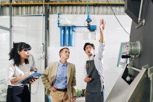 Facility manager explaining industrial equipment to inspectors during a site walkthrough