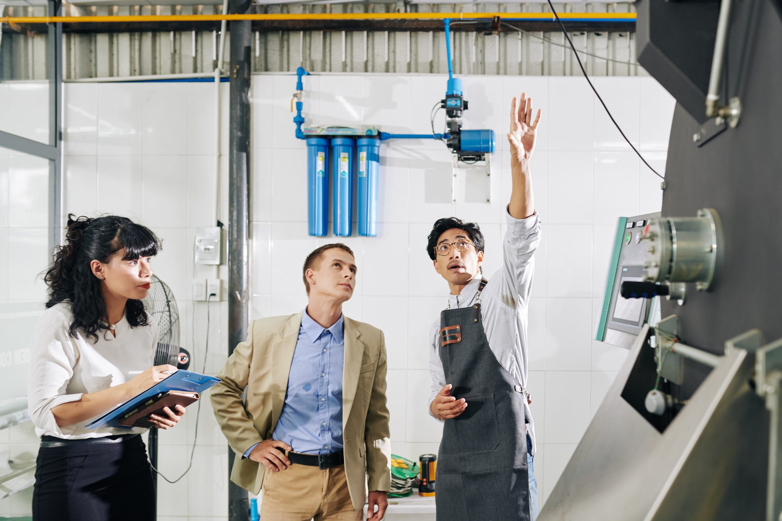 Facility manager explaining industrial equipment to inspectors during a site walkthrough